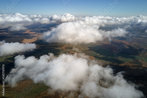 Fototapeta Naklejka Na Ścianę i Meble -  Aerial view from airplane window at high altitude of earth covered with white puffy cumulus clouds
