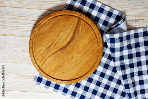 empty wooden round pizza tray and tablecloth on wooden background top view