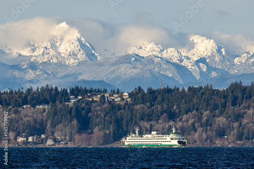 A ferry cross Puget Sound as snow covered Olympic Mountains loom in the background