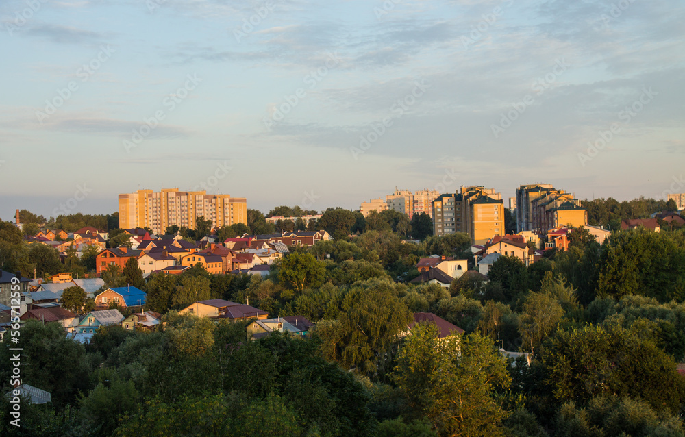 Panoramic top view of the modern houses of the residential area of the city of Vladimir in Russia and a park with lush green foliage of trees on a sunny summer morning