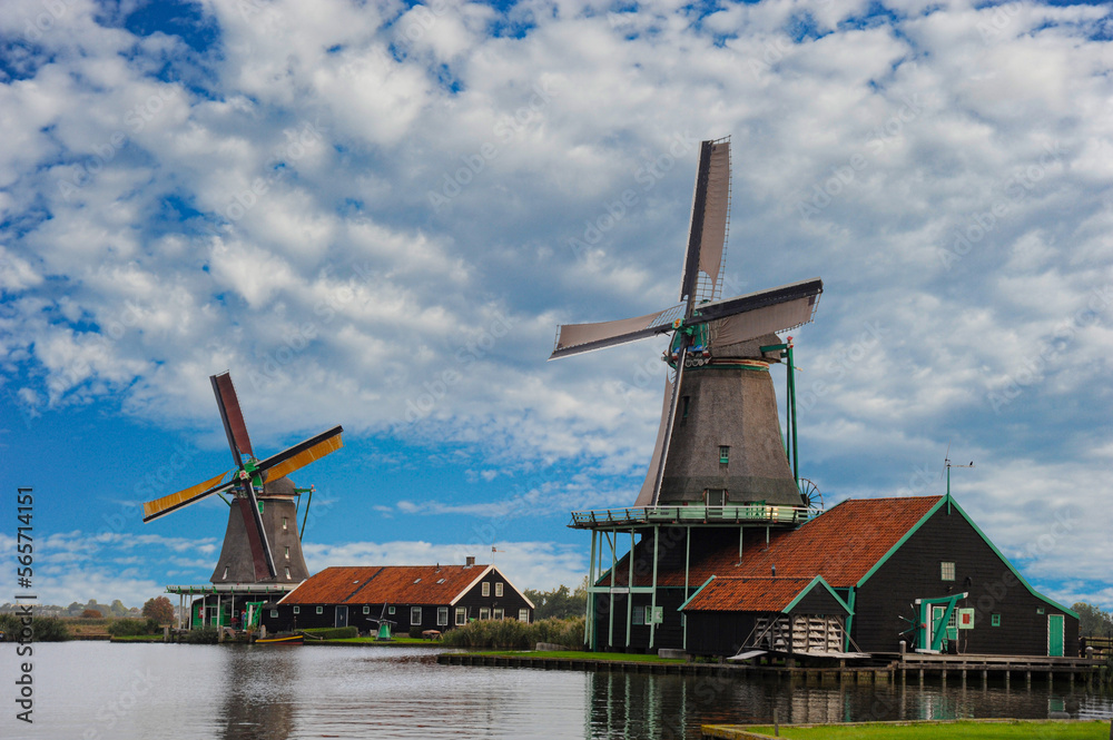 Skies starting to clear with two dutch windmills operating  in the Zaanse Shans area close to Amsterdam.	