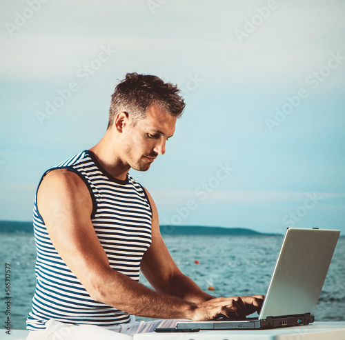 Man on the beach working on the laptop 