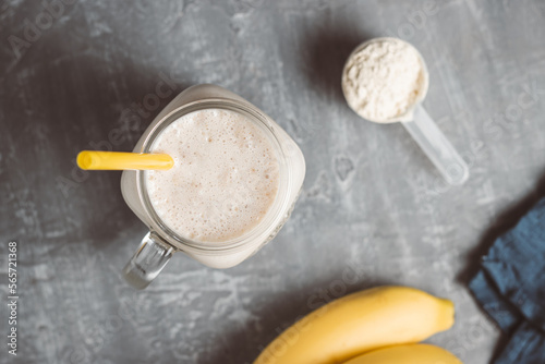 Banana smoothie with protein powder in a glass jar, top view, healthy eating concept
