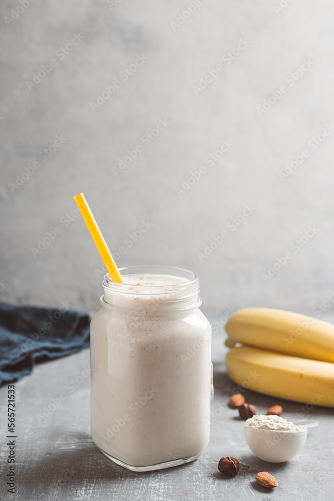 Banana smoothie with protein powder and nuts in a glass jar, healthy eating concept Banana smoothie with protein powder and nuts in a glass jar, healthy eating concept