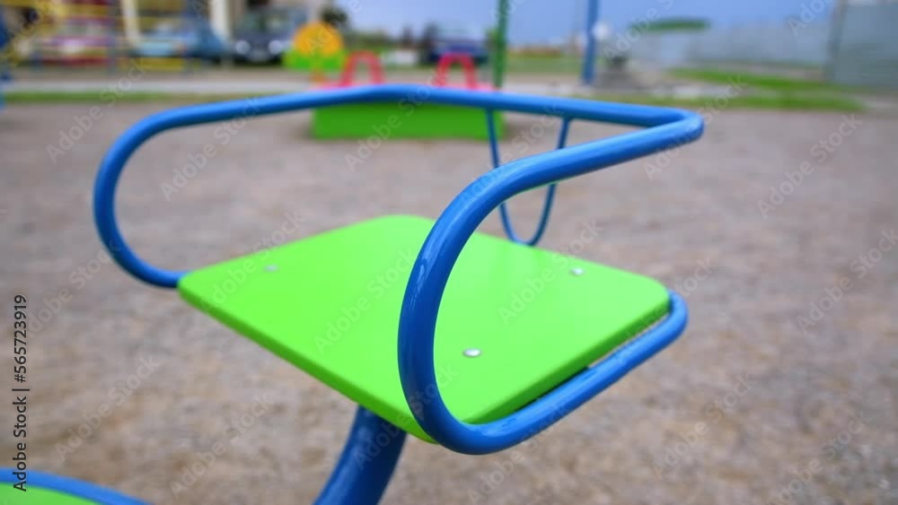 A seat on the children’s teeterboard on the playground. Rotating swing outdoors. Close up. Blurred backdrop. A seat on the children’s teeterboard on the playground. Rotating swing outdoors. Close up. Blurred backdrop.