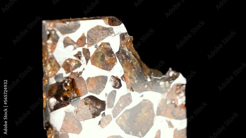 Rotating Of An Iron Meteorite. black background on a mirror base. Close ...