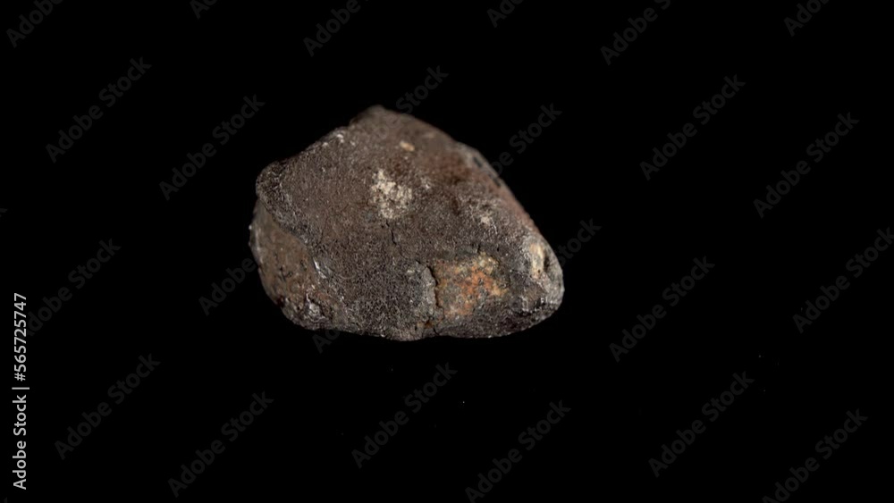 Rotating Of An Iron Meteorite. black background on a mirror base. general plan. Rotating Of An Iron Meteorite. black background on a mirror base. general plan.