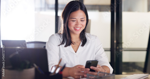 Business woman, phone and communication of a happy employee networking at a office desk. Company, corporate and worker with happiness texting, typing and working on a mobile phone with social media