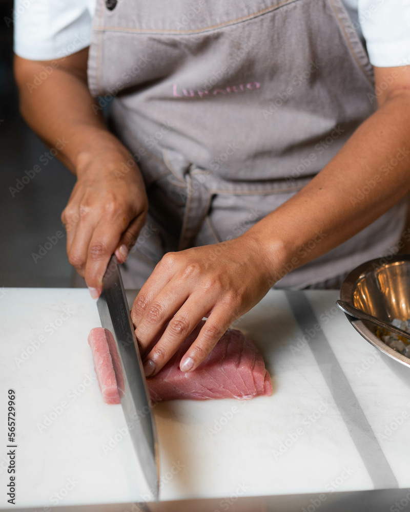 mano de chef cortando atun aleta azul atun aleta amarilla