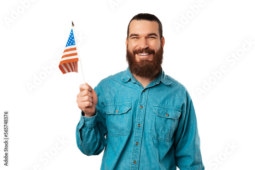 Handsome bearded man is holding a USA flag while wide smiling at the camera.