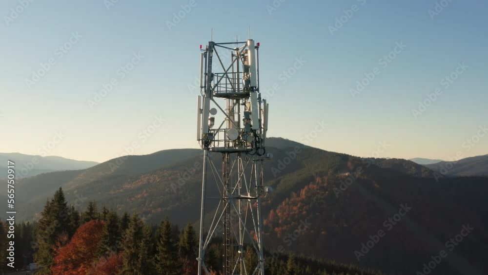 Close-up aerial view of a cell tower carrying antennas of cellular networks. Aerial footage of remote countryside with communication site and mountains around. High quality 4k footage Close-up aerial view of a cell tower carrying antennas of cellular networks. Aerial footage of remote countryside with communication site and mountains around. High quality 4k footage