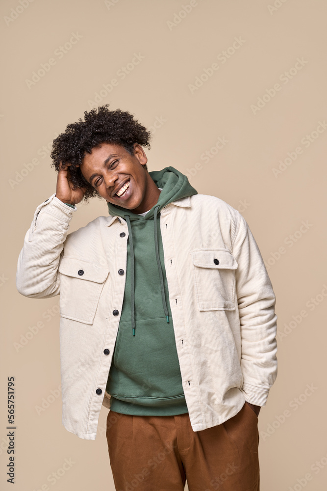 Happy young African American gen z guy isolated on beige background. Smiling hipster ethnic teen student, cool curly ethnic generation z teenager fashion model standing laughing, vertical shot. Happy young African American gen z guy isolated on beige background. Smiling hipster ethnic teen student, cool curly ethnic generation z teenager fashion model standing laughing, vertical shot.