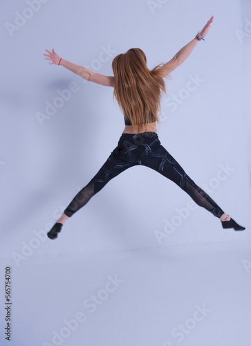 young woman with long hair jumping happy