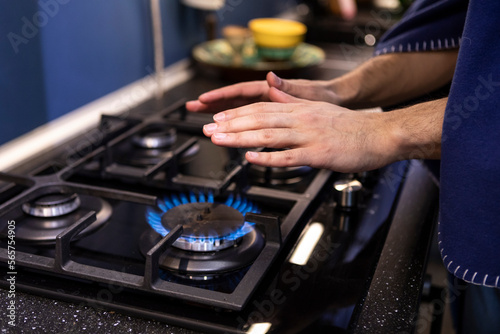 Close-up photo of freezing male hands warming close to gas oven. Cold winter and high price taxes concept