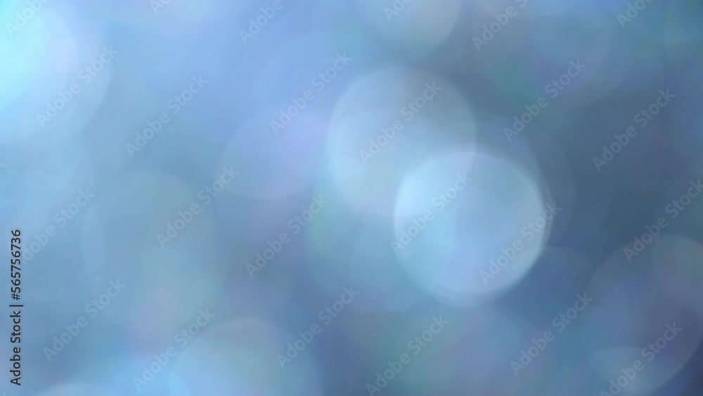 Glimmer blue bokeh moving background. Fading illuminated blue defocused circles shimmer, shine and sparkle in an abstract way. Relaxing 4K moving background can be used as an overlay or transition.