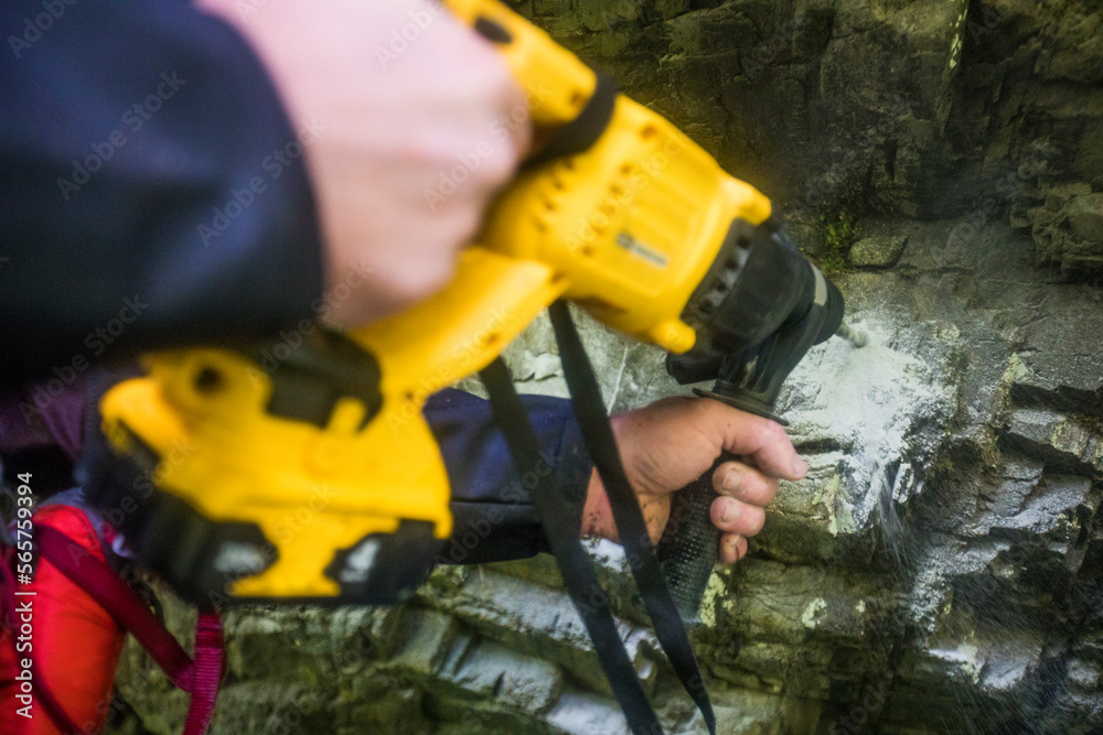 © Cavan Images - Drilling holes in rock in order to bolt in anchors for rappel station. © Cavan Images - Drilling holes in rock in order to bolt in anchors for rappel station.