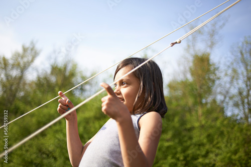 Young Asian girl playing with tent lines in summer sunshine photo