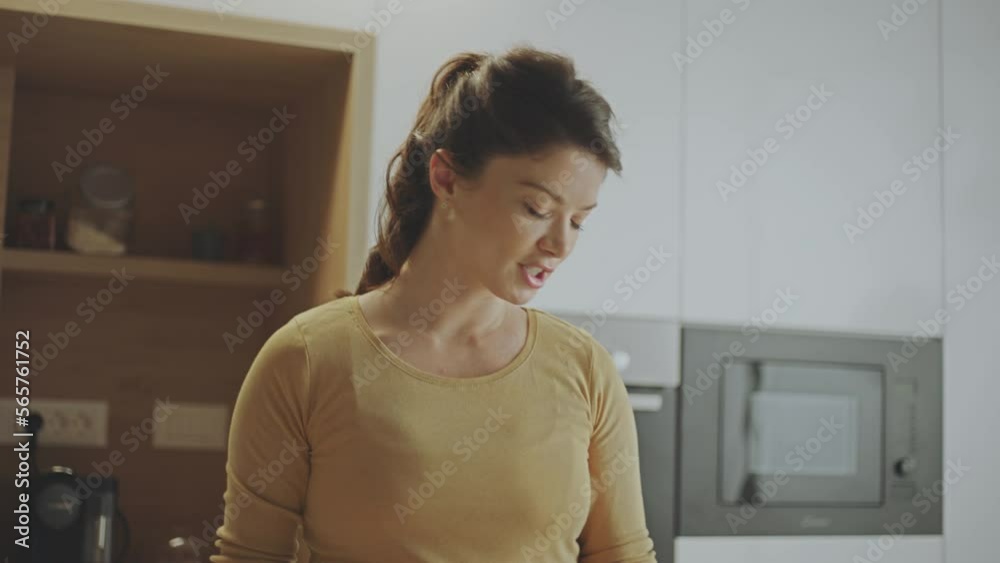 Close-up view of a beautiful woman preparing recipe while following cooking instructions on laptop in slow-motion Close-up view of a beautiful woman preparing recipe while following cooking instructions on laptop in slow-motion