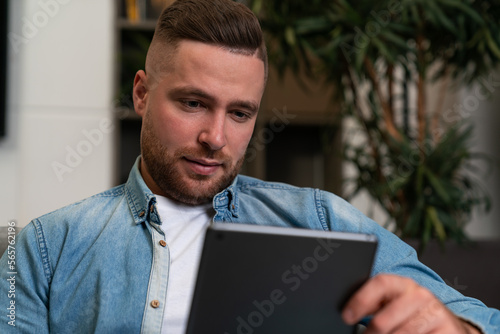 Young man portrait looking at tablet in hand