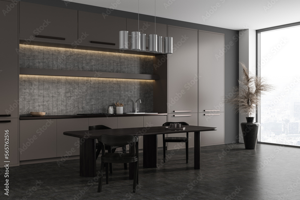 Fototapeta premium Dark kitchen interior with cooking area and dining table, panoramic window