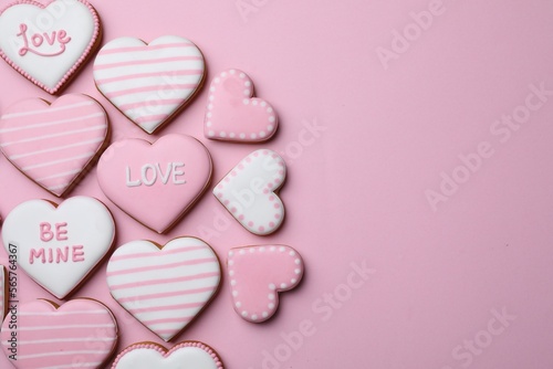 Delicious heart shaped cookies on pink background, flat lay. Space for text