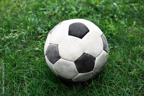 Dirty soccer ball on fresh green grass outdoors, closeup © New Africa