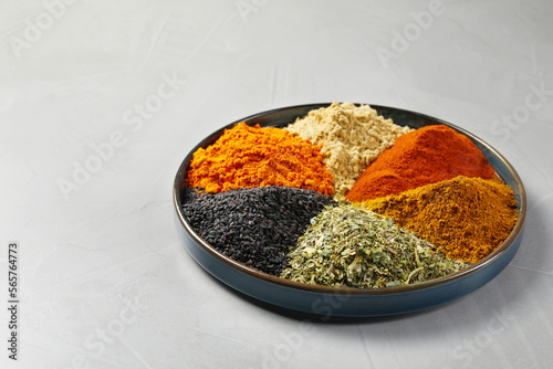 Fototapeta Naklejka Na Ścianę i Meble -  Plate with different spices on light grey table. Space for text