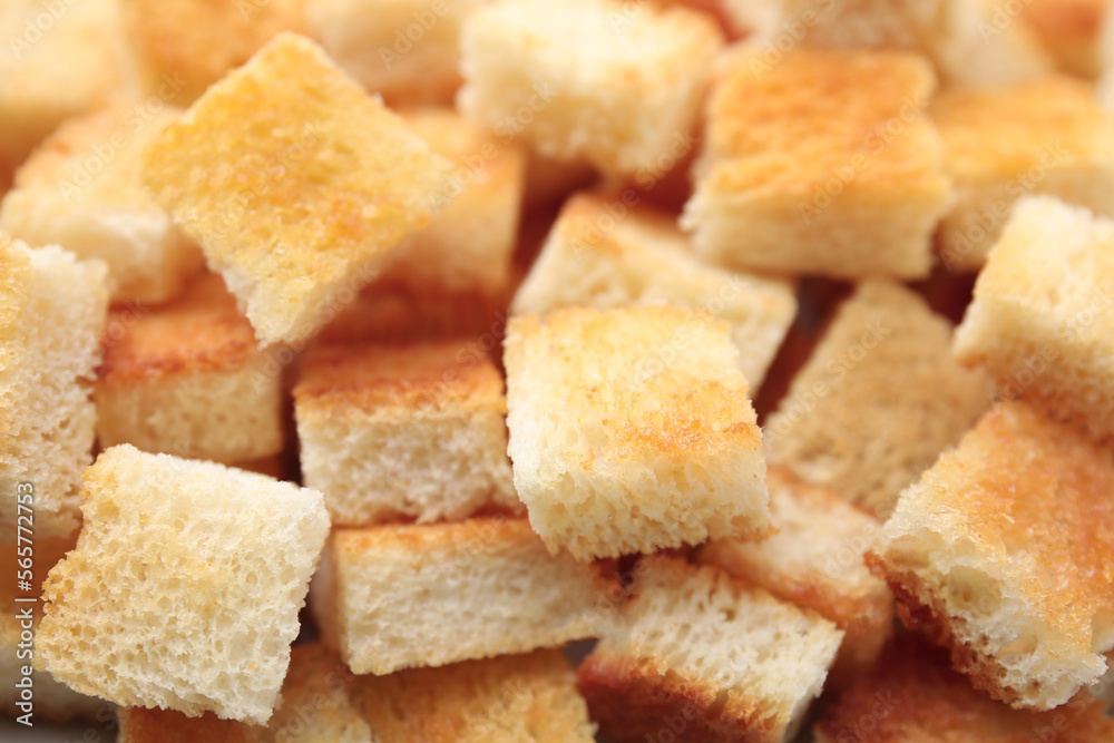 Delicious crispy croutons as background, closeup view
