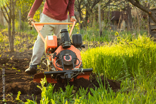 a small agricultural tractor plows the ground, the work of a walk-behind tractor. land treatment for planting.