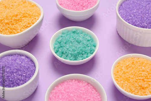 Different types of aromatic sea salt on purple background