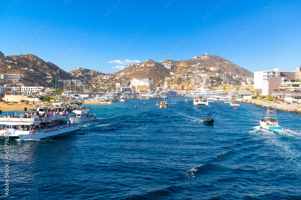 View from a boat in the bay of the marina, port town and hills of the Mexican resort town of Cabo San Lucas, Mexico.