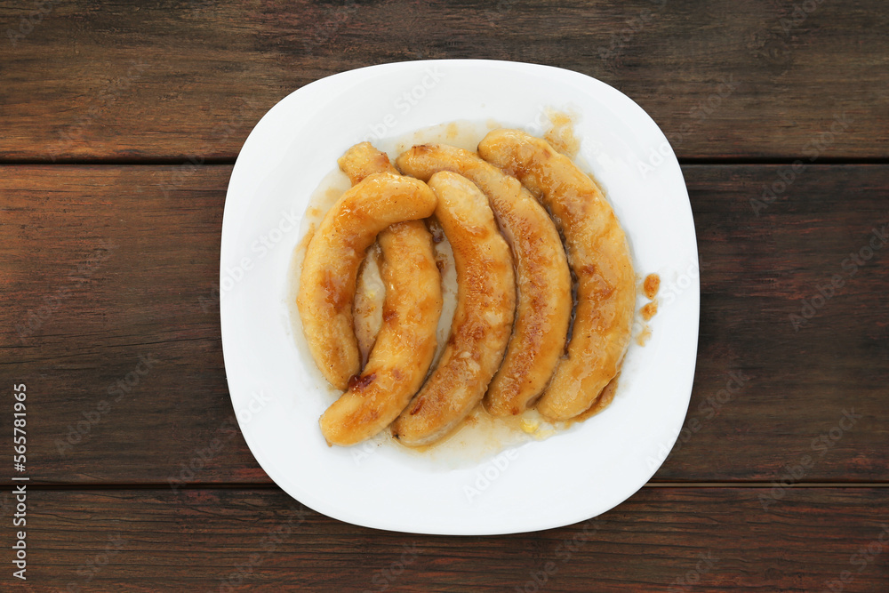 Plate with delicious fried bananas on wooden table, top view Plate with delicious fried bananas on wooden table, top view