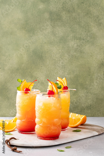 Rum punch in tiki glasses with orange slices and a cherry