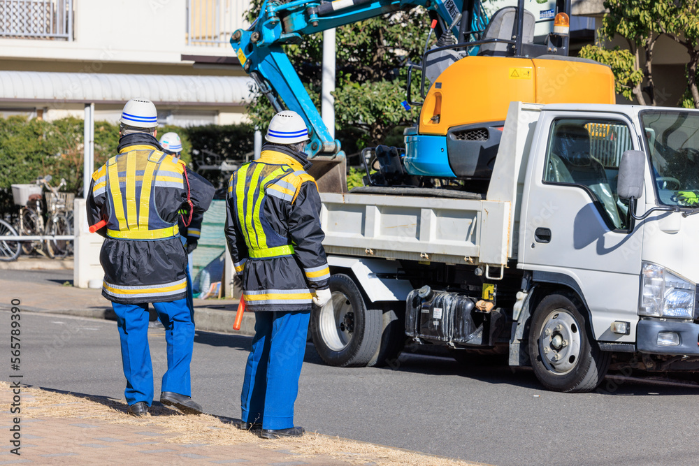 道路の補修工事の開始を待つ交通誘導員