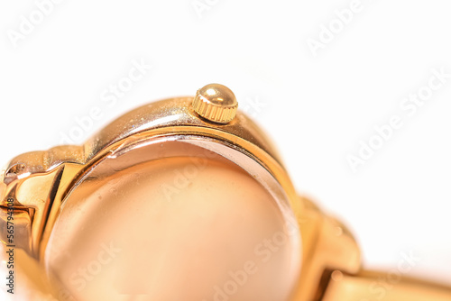 Women's Golden wrist watch on the white satin cloth.