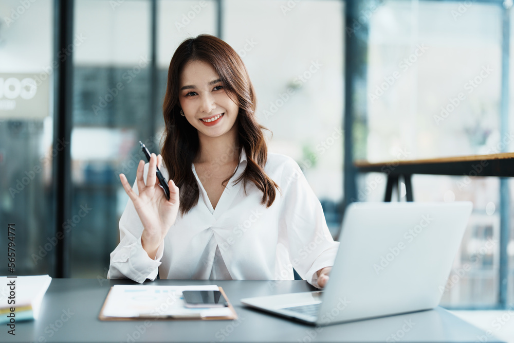 Portrait of a beautiful Asian teenage girl using computer for video conferencing at office Portrait of a beautiful Asian teenage girl using computer for video conferencing at office