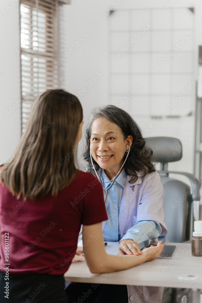 Elderly Asian female nurse teaches caucasian patient about advice and correct information. for the use of paracetamol to treat pain Elderly Asian female nurse teaches caucasian patient about advice and correct information. for the use of paracetamol to treat pain
