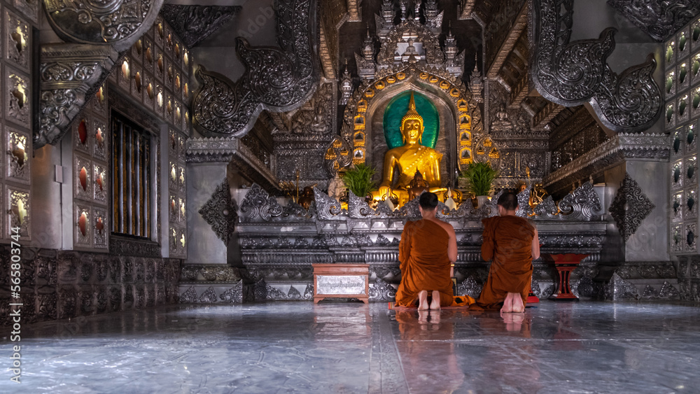Monks front of the Buddha statue inside the Silver Temple