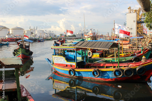 portrait of traditional fishing boats that lean on the dock beside the largest container port in Indonesia