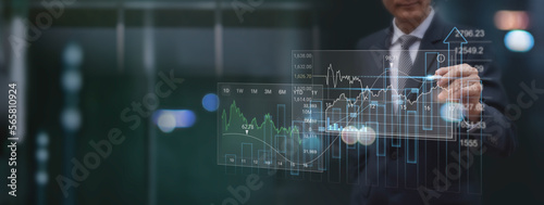 Finance analyst analyzing stock market report with financial data, economic graph growth chart on virtual screen with dark background, Business growth, finance and investment concept