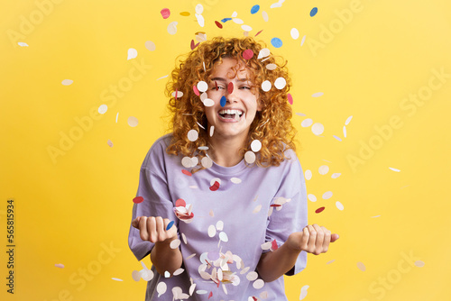 Cheerful woman surrounded by confetti in the air