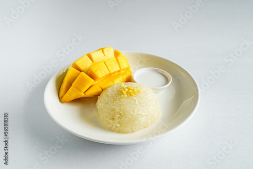 Fototapeta Naklejka Na Ścianę i Meble -  Fresh ripe mango and sticky rice with coconut milk. Traditional Thai dessert on white background.