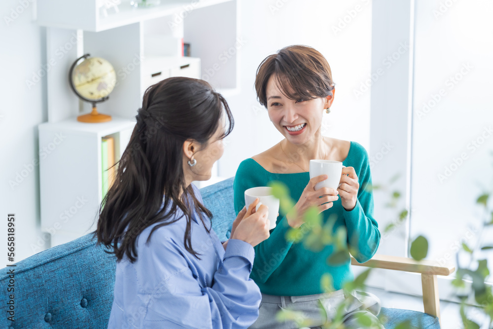コップを持ち話をする日本人女性 コップを持ち話をする日本人女性
