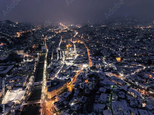 Sarajevo city hall or national library in town center aerialhyper lapse or time lapse. Landmark in capital of Bosnia and Herzegovina covered with fresh snow in the winter season at night.  photo