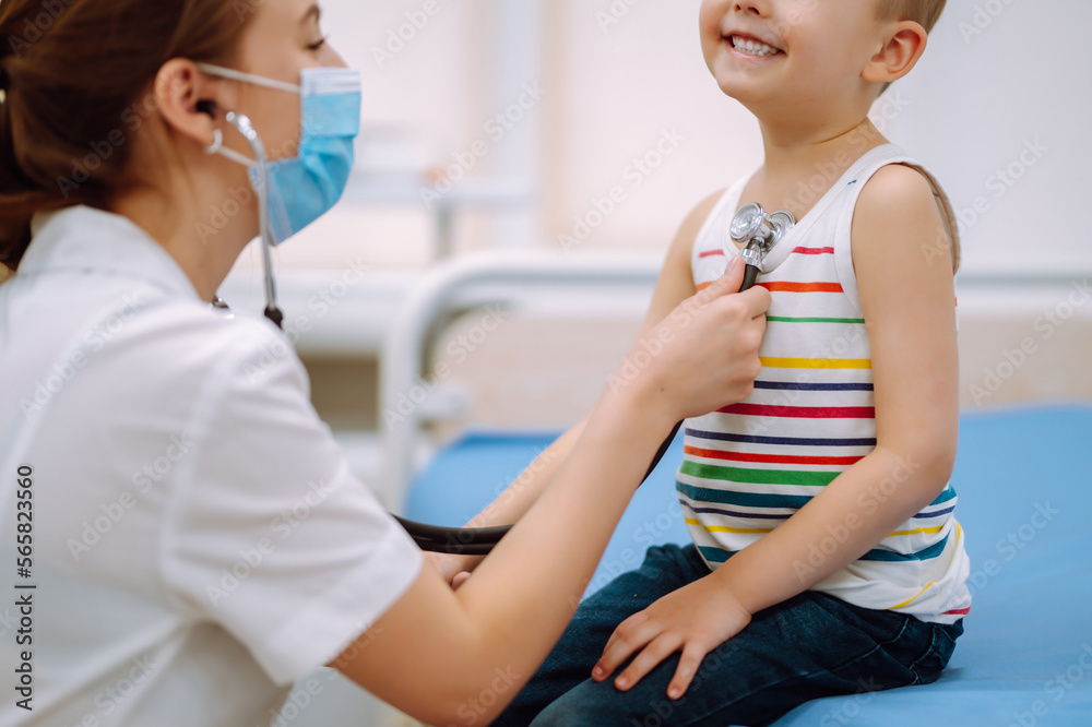 Fototapeta premium Doctor examining a little boy by stethoscope. Сhild's health.