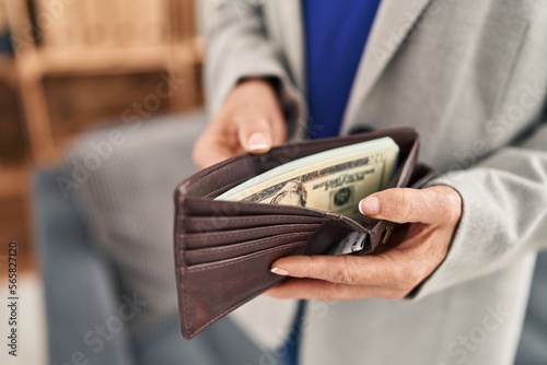 Middle age blonde woman business worker showing wallet with dollars at office