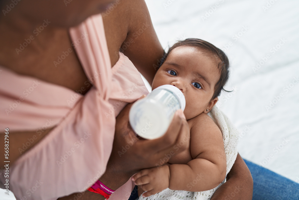 African american baby sucking feeding bottle at bedroom African american baby sucking feeding bottle at bedroom