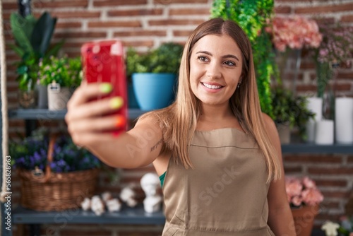 Young beautiful hispanic woman florist make selfie by smartphone at florist