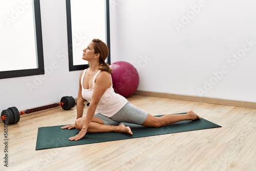 Young latin woman training yoga at sport center