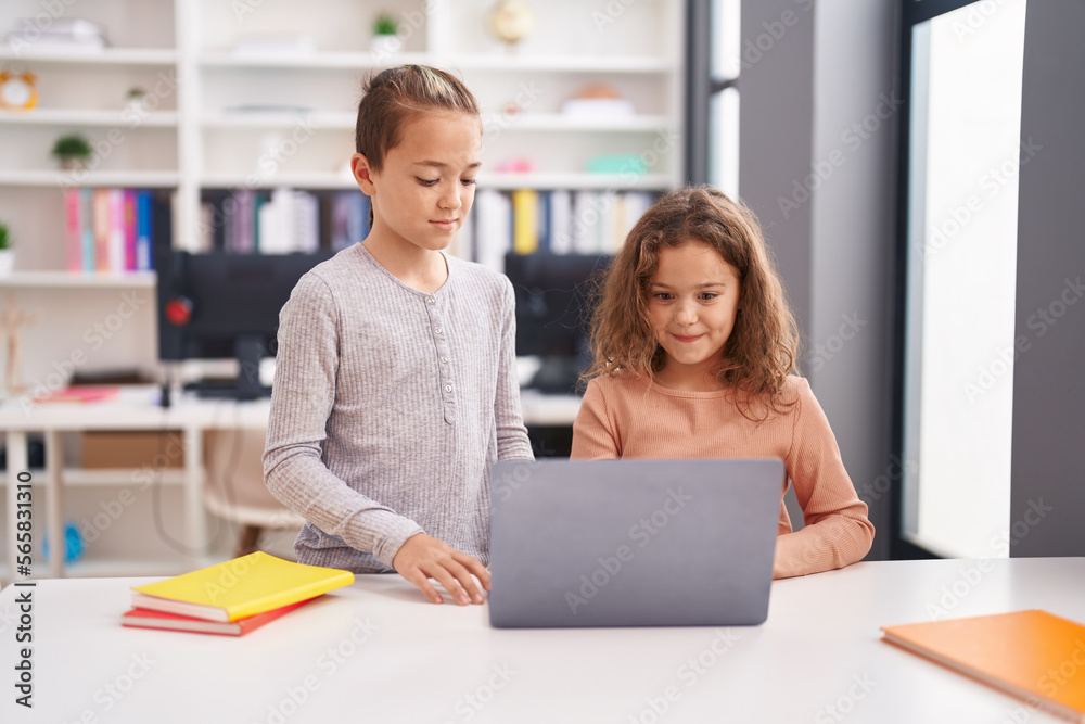 Two kids students using computer studying at classroom Two kids students using computer studying at classroom